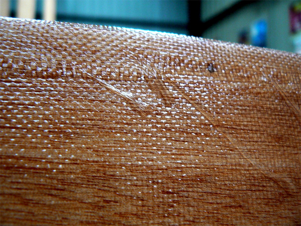 Encore une exclusivité Arwen Marine ! Voici ce qu'on ne vous montre jamais nulle-part ailleurs : le bord du tissu des bordés de fond s'effiloche naturellement quand on le travaille à l'époxy, c'est normal (mais pas beau, certes !) Le trou de suture bouché (tache sombre de 1.5 mm de diamètre) donne l'échelle. 