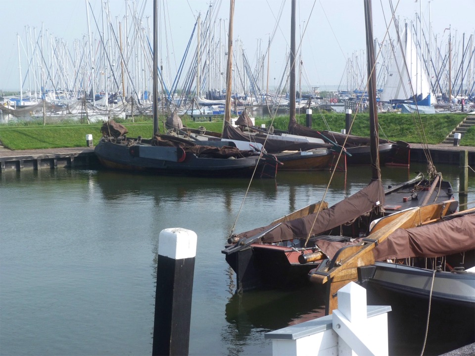 Reconstitution d'un petit port de pêche au musée du Zuiderzee à Enkhuizen. Lors de la construction de la grande digue de fermeture (afsluitdijk) du Zuiderzee, en 1932, l'état néerlandais a décidé de créer un musée pour préserver un témoignage de la vie dans les petits ports de pêche des bords de cette mer intérieure, appelée à être totalement asséchée. Finalement, seules des parties du Zuiderzee furent polderisées (la partie restante étant renommée en Ijselmeer, lac de l'Ijsel, la principale rivière s'y déversant), mais le musée fut tout de même ouvert en 1948, puis en 1983 pour sa partie en plein air. 