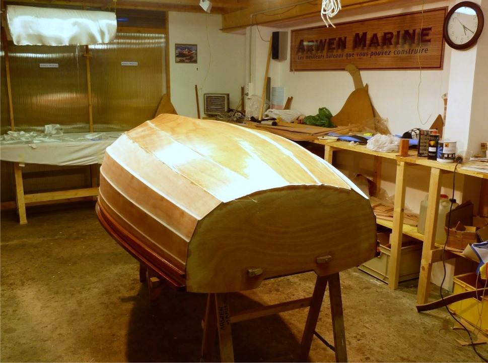 Une fois que toute la surface est saturée, je coupe l'excédent de tissu de verre au cutter sur le joint entre les bordés 2 et 3 de chaque coté, et avec des ciseaux le long du tableau arrière. Je recouperai au cutter au ras des extrémités des bordés quand l'époxy aura durci. 