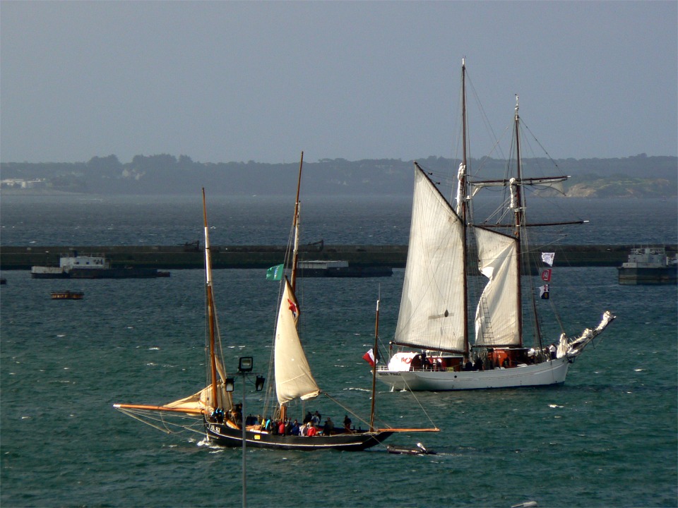 La "Belle Poule" en train d'envoyer sa misaine, bout au vent, pendant que la "Cancalaise" envoie ses voiles en traversant l'avant-port au moteur. Notez qu'il y a un ris dans le grand-voile de la "Cancalaise" alors que la "Belle Poule envoie toutes ses voiles basses, et je l'ai vue plus tard à peine gitée alors que ça soufflait bien (11 juillet). 