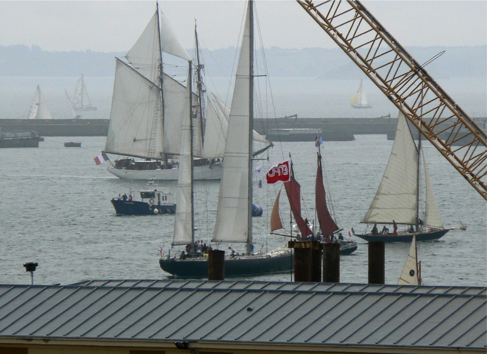 La "Belle Poule" traverse l'avant-port devant le premier et le dernier des "Pen Duick", occupés à établir leurs voiles. Je ne sais pas à qui sont les voiles rouges entre les deux "Pen Duick". 