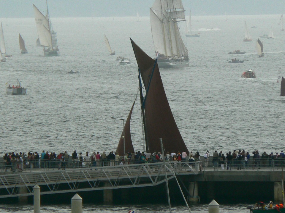 Etrange vision que cette voilure sombre qui passe seule à raser les spectateurs massés sur le môle du nouveau port du Moulin Blanc. 