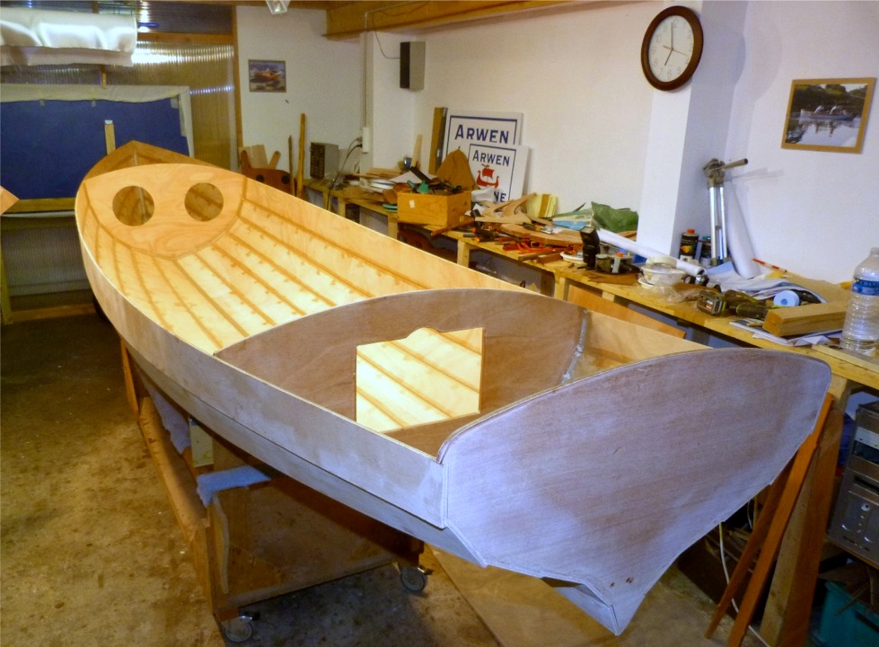 Après ce ponçage champêtre, nous rentrons la yole dans la partie chauffée de l'atelier afin de faire les joints sur l'intérieur de la coque, et boucher les trous des sutures. On voit clairement les endroits où nous avons mis de l'époxy "fraîche". 