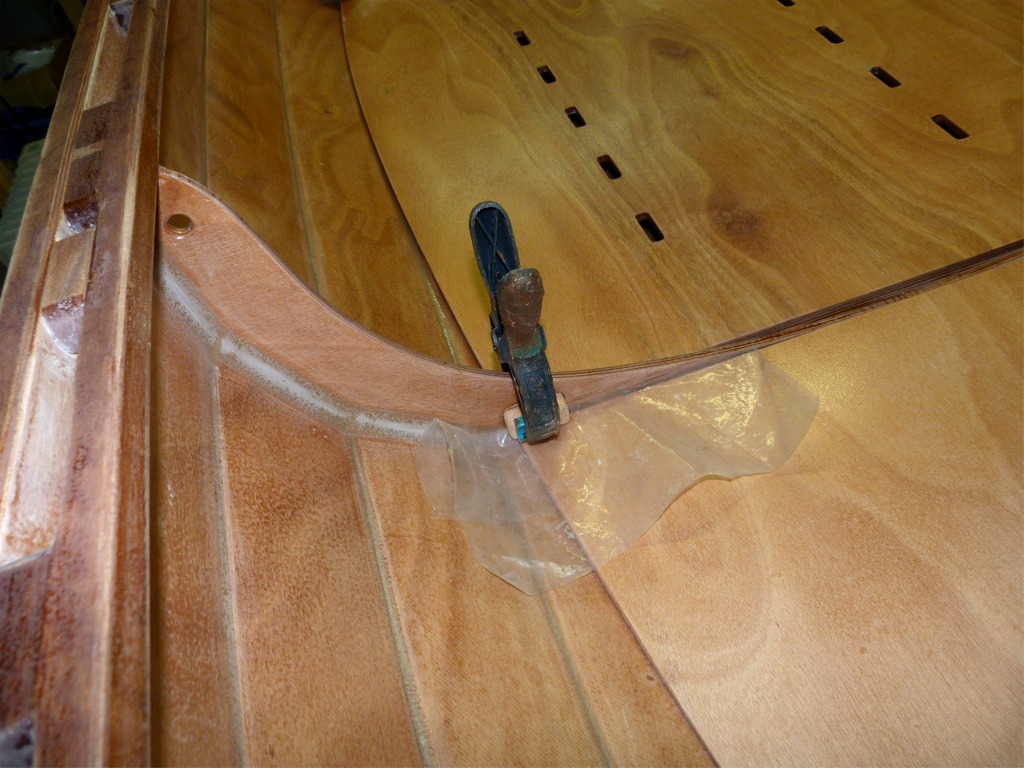 Voici une astuce de Pierre pour bloquer les planchers avant et arrière : un bloc de sapelli est collé sur la membrure sur bâbord et tribord. On engage le bord arrière du plancher avant dessous et la gravité fait le reste. Il n'y a que si la yole est inondée que le plancher flottera et s'évadera : inderdiction de chavirer avec les planchers en place... Il faudra peut-être compléter par un petit verrou mobile. 