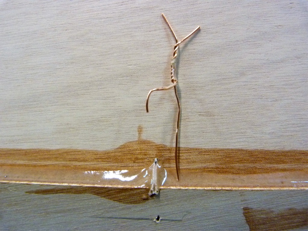 Le lendemain, Pierre est de nouveau là pour m'aider, et nous coupons toutes les sutures des joints que nous avons collés et nous les extrayons en les chauffant très modérément au décapeur. L'image montre le joint d'où une suture a été extraite : l'époxy chargée fait une "vague" là où la suture a géné le lissage à la cuiller. 