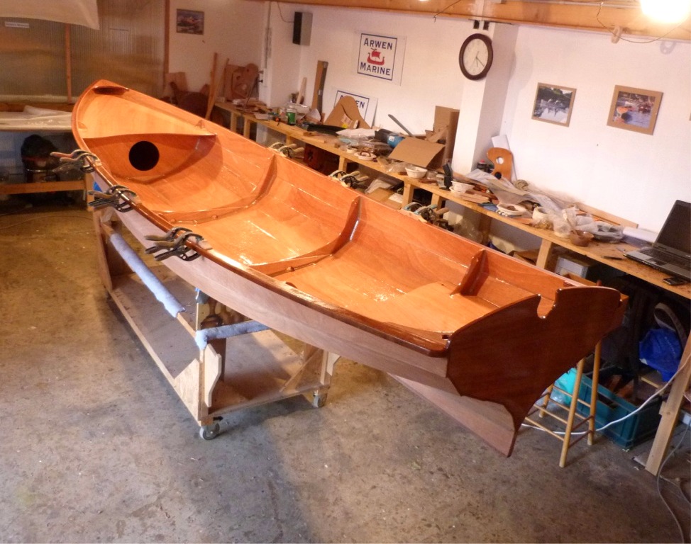 J'ai remis la Yole de Chester à l'endroit pour la dernière ligne droite (de la construction, après il restera le vernis et la peinture). Je viens de passer une couche d'époxy sur toute la surface intérieure, puis de coller les toletières sur les listons. 