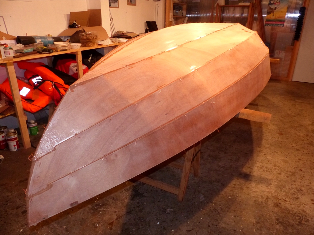Mon assistante est passée à l'atelier pour m'aider à tourner la coque qui ne pèse encore que 27 kg sans les trois sièges (pour les bons en calcul mental, j'ai donc bien ajouté 500 g d'époxy chargée). J'ai ensuite déposé un cordon d'époxy chargée assez fluide (consistance "ketchup") le long de tous les joints entre la sole et les 6 bordés, y-compris l'étrave et l'étambot. 
