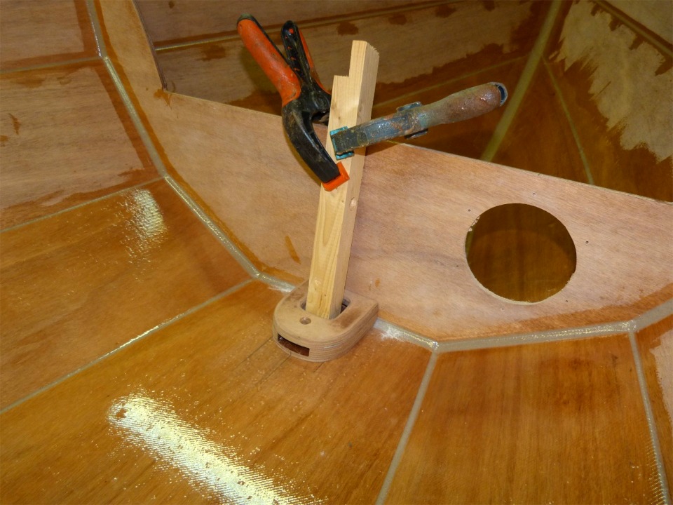Cette chute de tasseau tenue par les deux pinces me sert à immobiliser le pied de mât à sa place au pied de la cloison avant. J'ai percé les trous de ses 4 vis de fixation par l'intérieur, les ai fraisés par l'extérieur (pour les têtes des vis), puis ai marqué le pied de mât en perçant légèrement à travers les trous. Plus qu'à démonter le tasseau, retourner le pied de mât et faire de vrais avant-trous de la bonne profondeur. 