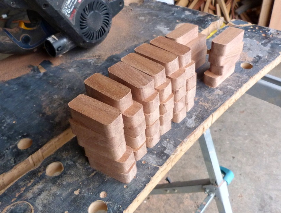 Evidemment, ma décision d'installer une serre sur cales ne va pas dans le sens de la simplification... Je commence par découper 38 cales de sapelli et j'arrondis leurs 4 angles. J'ajouterai encore deux cales après avoir décidé d'ajouter une troisième position de nage (pour nager en simple ou en double). 