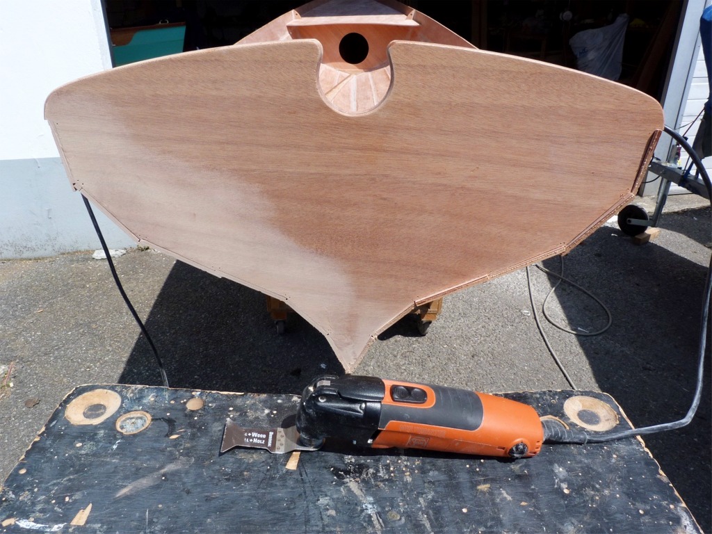 Dans la foulée, je coupe l'extrémité des virures au ras du tableau à l'aide de la scie oscillante que l'on aperçoit au premier plan, puis je passe un coup de ponceuse orbitale. On voit que j'ai traité le tableau sur bâbord, et point encore sur tribord. Et au passage, admirez la délicatesse du dessin de ce tableau arrière... 