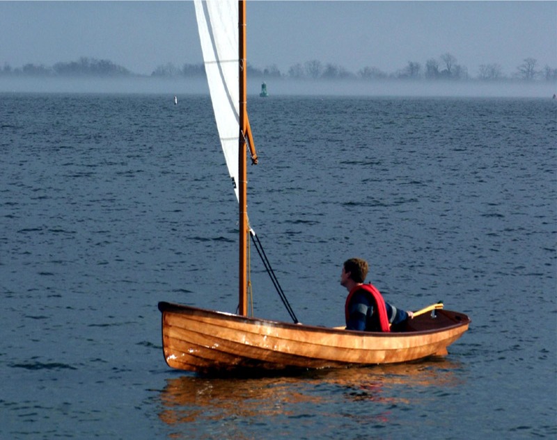 Cette photo d'une Yole de Chester équipée du gréement standard du Skerry avec sa voile de 5.10 m2 à livarde montre que nous ne sommes pas les premiers à gréer la yole. C'est John C. Harris, son architecte (et patron de Chesapeake Light Craft, dont Arwen Marine est l'agent pour la France) qui est à la barre. La photo date de 2007, lorsque John a lui-même testé une yole gréée. 